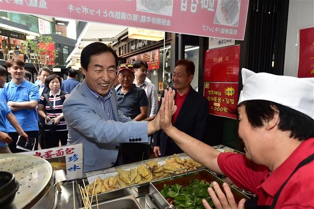 문 구청장(왼쪽)이 2018년 9월 15일 오후 신촌기차역 앞 ‘신촌 박스퀘어’ 개관식에서 입점 상인과 하이파이브를 하고 있다. 서대문구 제공