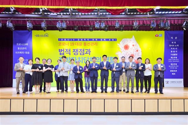 지난 9일 송파구청 강당에서 ‘코로나 대응 동선관리의 법적 쟁점과 지방자치단체의 역할’을 주제로 열린 송파구·한국공법학회 공동주체 포럼에서 박성수(왼쪽 열두 번째) 송파구청장과 이원우(열한 번째) 한국공법학회장 등 참석자들이 덕분에 챌린지를 하고 있다. 송파구 제공