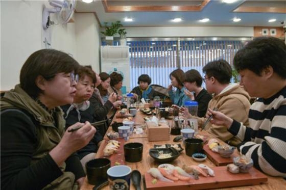 지난 3월 영등포구 당산1동 주민들이 당산골 ‘손수가게 기획단’에 참여해 손수가게 선정 후보로 꼽힌 식당 ‘스시우이’를 방문해 시식하고 있다. 영등포구 제공