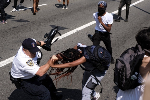 ‘Black Lives Matter(블랙 라이브즈 매터: 흑인의 목숨도 소중하다)’ 시위대가 15일(현지시간) 미국 뉴욕 브루클린 다리에서 시위 중에 뉴욕 경찰과 실랑이를 벌이고 있다. 뉴욕시 경찰 몇 명이 시위 도중 공격을 받고 부상을 입었으며 12명 이상이 체포되었다고 밝혔다. AP 연합뉴스