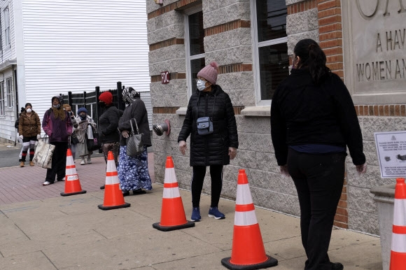 지난 4월 23일(현지시간) 미국 뉴저지주의 한 푸드뱅크에서 시민들이 음식을 받아가려 줄을 서 있다. AP통신