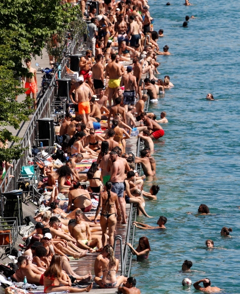 코로나19 확산 위험에도 불구하고 20일(현지시간) 스위스 취리히의 리마트 강변에서 시민들이 수영과 일광욕을 즐기고 있다. 로이터 연합뉴스