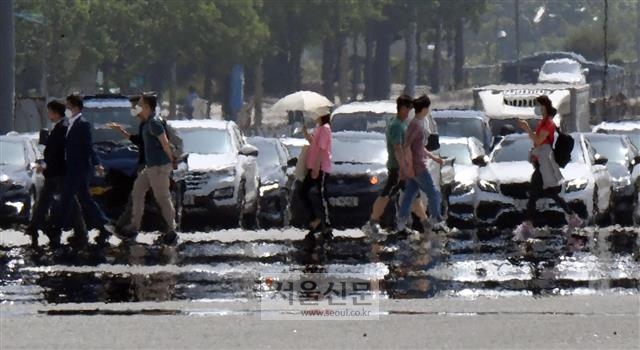 올해 6월은 역대 가장 더운 6월로 기록됐다. 때 이른 폭염으로 낮 기온이 30도까지 오른 6월 3일 서울 여의도에서 시민들이 힘겹게 도로를 횡단하고 있다. 박지환 기자 popocar@seoul.co.kr
