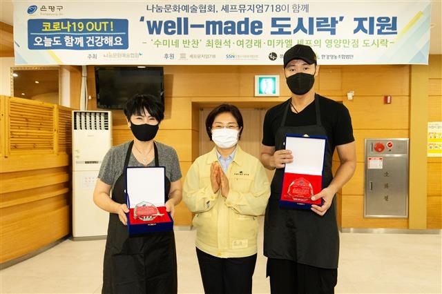 김미경(가운데) 은평구청장이 21일 구청 구내식당에서 유현숙(왼쪽) 나눔문화예술협회 이사장, 최현석 셰프에게 ‘웰메이드 도시락’ 지원 사업 감사패를 전달한 뒤 기념사진을 찍고 있다. 이날 코로나19 장기화로 인해 식생활에 어려움을 겪는 독거노인 등 취약 계층에게 전달하기 위해 유명 셰프 등이 참가해 도시락 300여명분을 만들었다. 은평구 제공