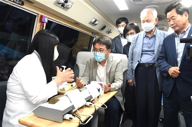 오승록(왼쪽 두 번째) 노원구청장이 지난 17일 노원구청 신관 주차장에서 열린 이동 건강버스 개통식에서 버스에 올라 구보건소 관계자에게 검진에 대한 설명을 듣고 있다. 노원구 제공