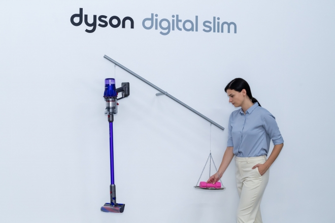 다이슨 신제품  ‘다이슨 옴니-글라이드™’, ‘다이슨 디지털 슬림™’ 런칭 이벤트 현장에서 다이슨코리아 트레이너가 2kg 아령과 1.9kg 다이슨 디지털 슬림™ 을 저울에 올려 무게를 비교하고 있다.
