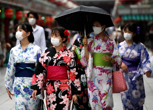 일본 도쿄의 아사쿠사를 찾은 여성들이 22일 전통 의상인 유카타에 마스크를 하고 있다. 2020.7.22  로이터 연합뉴스