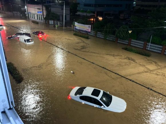 부산 지역에 호우 경보가 내려진 23일 오후 부산 연산동 한 도로가 침수 돼 차량이 물에 잠겨 있다. 2020.7.23  부산 경찰청 제공