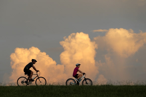 지난 14일(현지시간) 사람들이 미국 미시시피강 인근에서 자전거를 타고 있다. AP통신