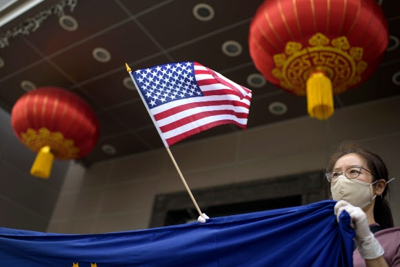 미국이 텍사스주 휴스턴의 중국 총영사관을 폐쇄한 24일(현지시간) 영사관 밖에서 항의 시위대가 미국 국기를 흔들고 있다.  휴스턴 AFP 연합뉴스