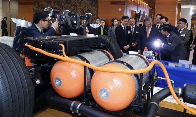 문재인 대통령이 지난해 1월 17일 울산시청 대회의실에서 열린 ‘수소 경제와 미래에너지, 울산에서 시작됩니다’란 행사 참석에 앞서 둘러본 수소 활용 전시장에서 관계자에게 수소 연료전지 등에 대한 설명을 듣고 있다. 연합뉴스