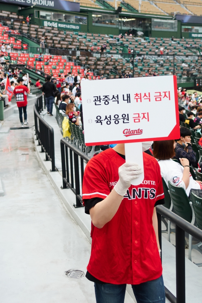 사직구장 안내요원이 안전수칙이 적힌 안내판을 들고 경기장을 돌고 있다. 부산 류재민 기자 phoem@seoul.co.kr