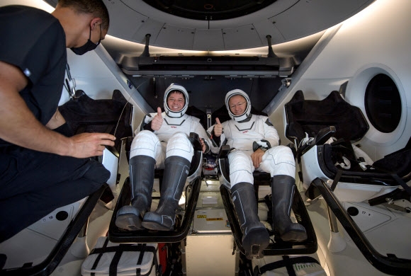 로버트 벤켄(왼쪽)과 더그 헐리 두 미 항공우주국(NASA) 우주비행사가 3일(한국시간) 스플래시다운 방식으로 지구에 돌아온 뒤 스페이스X의 유인 캡슐 크루 드래건 조종석에 앉아 엄지를 들어 보이며 웃고 있다. NASA 제공 AP 연합뉴스