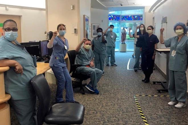미국 캘리포니아주 산타 모니카에 있는 프로비던스 세인트 존스 건강센터에 있는 의료진들이지난 4월 코로나19 환자들을 돌보는 이들과의 연대 차원에서 쥐먹을 쥐어 보이고 있다. 산타 모니카 AP 연합뉴스