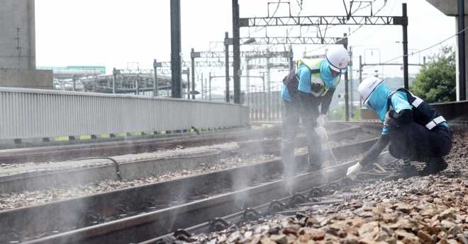 사진은 2018년 7월 25일 인천 계양구 계양역에서 인천교통공사 노동자들이 땡볕에 달궈진 철로를 식히며 점검하고 있는 모습. 2018.7.25 연합뉴스