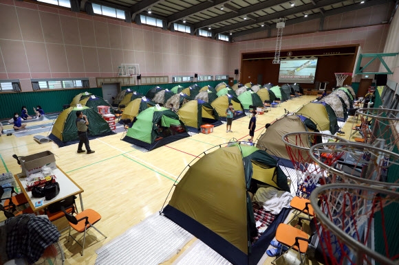 10일 전남 구례군 구례여자중학교 강당에 마련된 이재민 대피소에 주택 침수 피해를 본 주민이 생활하는 텐트가 줄지어 있다. 2020.8.10  연합뉴스