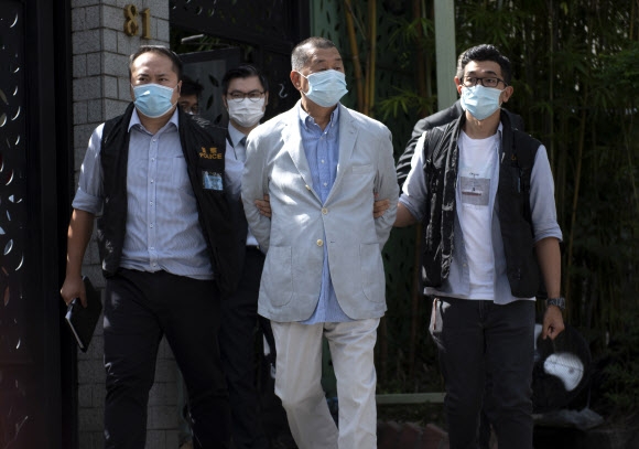 홍콩의 반중 민주화 시위를 이끌거나 뒷받침한 홍콩 언론계의 거목 지미 라이(가운데)가 10일 오전 자택에서 국가안보처 요원에 의해 체포돼 연행되고 있다. 홍콩 EPA 연합뉴스 