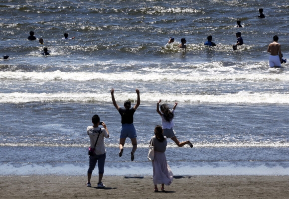 11일(현지시간) 일본 도쿄 인근 후지사와의 한 해변에서 시민들이 더위를 식히고 있다. AP 연합뉴스