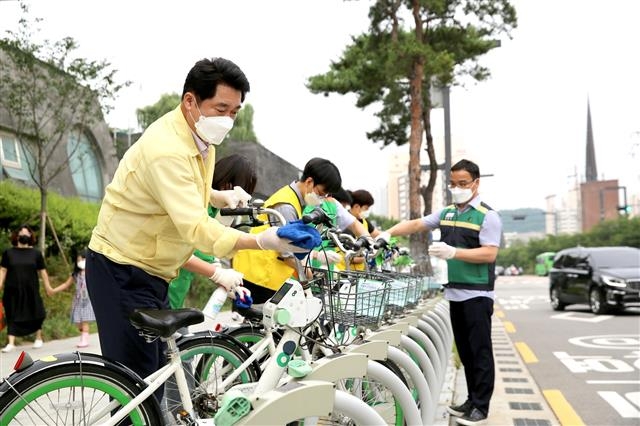 박준희(왼쪽 첫 번째) 관악구청장이 지난 6월 말부터 2주간 진행된 코로나19 집중방역주간에 직원, 통장 등과 함께 따릉이 등 지역 내 공공시설물을 방역 소독하고 있다. 관악구 제공