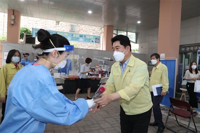 지난달 1일 박 구청장(오른쪽)은 장미꽃 1583송이를 구보건소 선별진료소 의료진과 구청 공무원들에게 나눠 주며 취임 2주년 일정을 시작했다. 관악구 제공