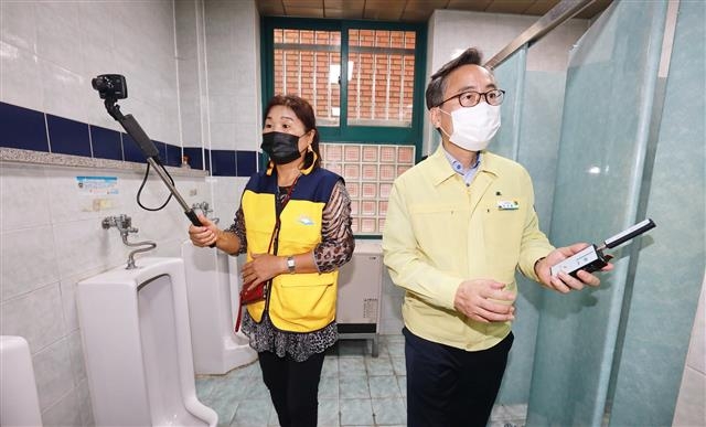 유성훈(오른쪽) 금천구청장이 지난 6일 여성친화도시 주민 참여단원과 함께 학교 화장실 불법촬영 카메라 설치 여부를 점검하고 있다. 금천구 제공