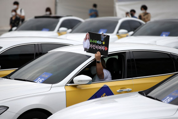 13일 오전 서울 성동구 비트플렉스 5층 야외 주차장에서 SK텔레콤이 개최한 갤럭시 노트20 5G 드라이브 스루 행사에서 고객이 드라이브 스루 방식으로 갤럭시 노트20을 수령하고 트로트 가수 송가인의 공연을 감상하고 있다. 2020.8.13 <br>연합뉴스