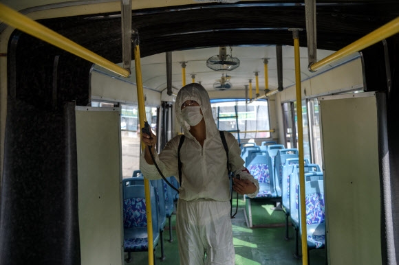 13일 북한 평양의 한 버스 직원이 코로나19 비상방역을 위해 버스를 소독하고 있다. AFP 연합뉴스