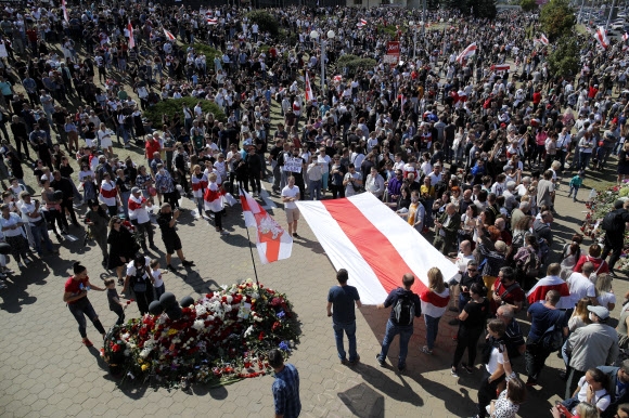 벨라루스 대선 결과에 불복하는 시위에 참여한 시민들이 15일(현지시간) 시위 도중 목숨을 잃은 알렉산데르 타라이코프스키 장례 도중 국기를 펼친 채 그의 죽음을 기리고 있다. 민스크 AP 연합뉴스 