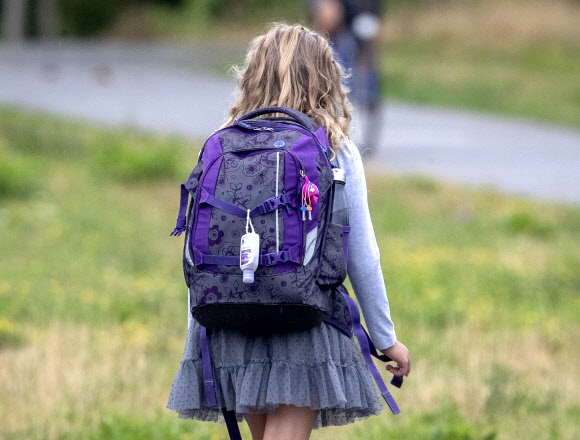 한 소녀가 17일(현지시간) 독일 프랑크푸르트에 있는 독일 연방 주 헤세에서 학교 가방에 소독제를 매달고 등교하고 있다. AP 연합뉴스