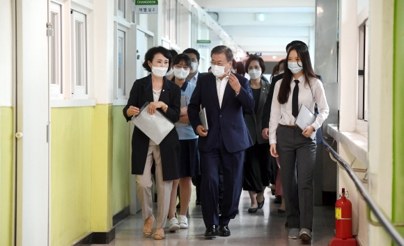 문재인 대통령이 18일 한국판 뉴딜 10대 과제 중 하나인 ‘그린 스마트스쿨’ 현장인 서울 중구 창덕여중을 방문, 테크센터에서 수업에 사용할 태블릿을 수령한 뒤 교실로 이동하고 있다. 2020. 8. 18 도준석 기자pado@seoul.co.kr