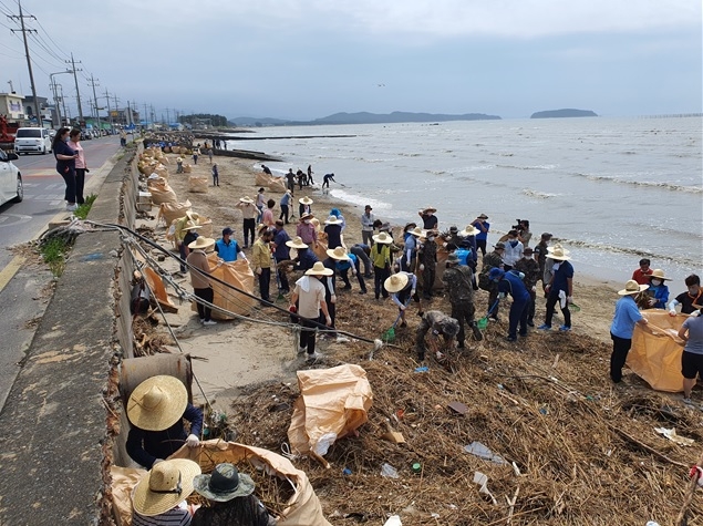 충남 서천군 주민들이 지난 14일 서면 남촌 해안에서 큰 장마 때문에 금강에서 흘러들어온 해양쓰레기를 수거하고 있다. 서천군 제공