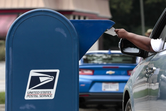 22일(현지시간) 한 남성이 미국 오하이오주의 한 우체통에 우편물을 넣고 있다. AP