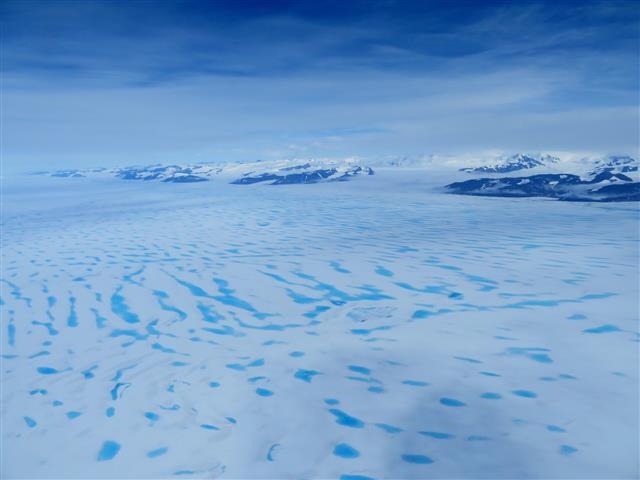 여름철 기온 상승으로 남극 조지6세 빙붕 표면의 얼음이 녹아 곳곳에 물웅덩이가 생긴 모습. 표면에 생긴 물웅덩이는 빙붕의 균열을 만들고 이는 빙붕이 붕괴되기 쉽게 만든다. 유럽우주국(ESA) 제공