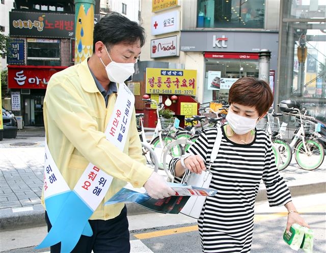 이창우 동작구청장이 지난 24일 낮 동작구 노량진역 인근에서 주민들에게 코로나19 방역수칙 준수를 안내하는 홍보물을 건네고 있다. 동작구 제공