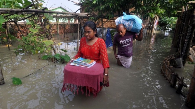 올해 인도 비하르주에 닥친 홍수로 가재도구와 책을 가지고 대피하는 현지 주민들. 게티 이미지