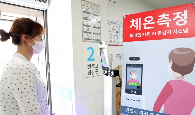 서울 동작구 노량진1동 주민센터에 설치된 비대면 자동 AI 열감지 시스템을 통해 민원인이 발열 점검을 하고 있다.  동작구 제공 