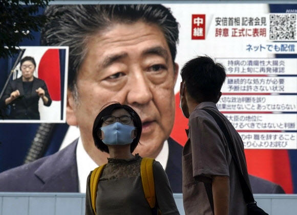 일본 도쿄 행인들이 지난 28일 아베 신조 총리가 사임을 발표하는 중계방송을 지켜보고 있다. 아베 총리가 이날 기자회견에서 건강 악화를 이유로 사퇴한다고 밝히면서 후임 총리에 관심이 쏠리고 있다. 도쿄 EPA 연합뉴스