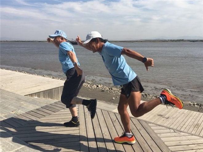 2018년 10월 6일 지구 달리기 526일째 중국 단둥에 도착한 강명구(오른쪽) 평화 마라토너와 송인엽 한국교원대 교수가 두 발로 압록강을 건너 뛰는 퍼포먼스를 하며 즐거워하고 있다. 