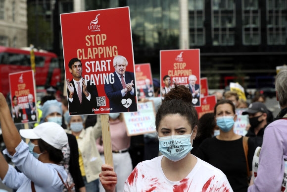 영국 국민보건서비스(NHS) 직원들이 런던의 세인트 토머스 병원 앞에서 임금 인상을 요구하며 시위를 벌이고 있다-연합뉴스