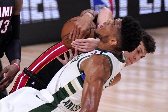 미프로농구(NBA) 밀워키 벅스의 Milwaukee Bucks’ Giannis 야니스 아데토쿤보가 7일(한국시간) NBA 플레이오프 동부콘퍼런스 2라운드 4차전에서 마이애미 히트의 루키 타일러 히로와 공을 다투다 뒤엉켜 넘어지고 있다. AP 연합뉴스