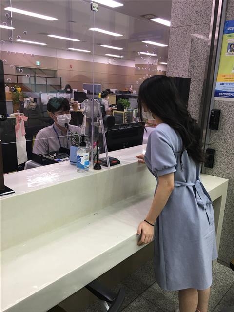 용인 수지구 민원실의 직원과 민원인이 ‘양방향 마이크’로 소통하고 있다. 수지구는 코로나19 전염을 막기 위해 민원실에 양방향 마이크를 설치했다. 용인시 제공