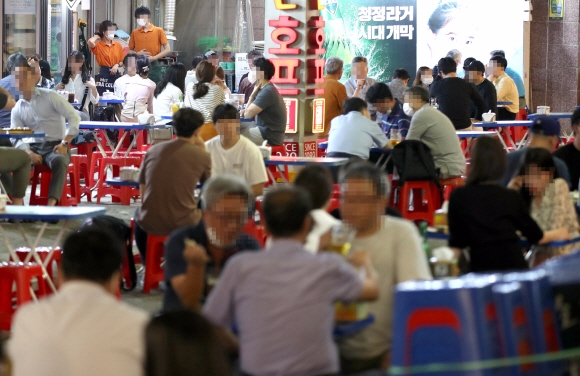 서울 중구 을지로 노가리 골목에서 시민들이 술잔을 기울이고 있다. 코로나19 확산 방지를 위해 테이블을 건너 띄어 앉은 모습이 눈에 띈다. 연합뉴스