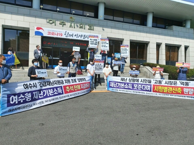 여수시민협 회원 30여명이 지난 7일 여수시의회 앞에서 집회를 열고 “여수시는 전 시민에게 긴급재난지원금을 추석전에 지급하라”고 요구하고 있다.