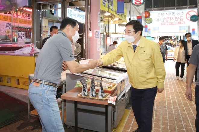 시장 상인과 주먹을 부딪치며 인사를 나누는 이동진 도봉구청장