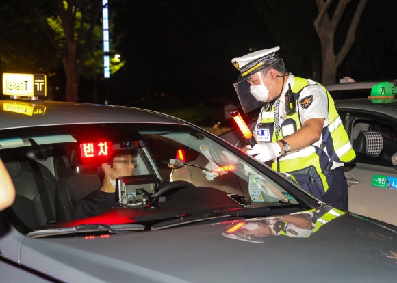 경기 수원시 팔달구의 한 도로에서 경찰관이 마스크를 2중으로 착용하고 비접촉 음주감지기를 활용해 음주운전 단속을 하고 있다. 경기남부경찰청 제공
