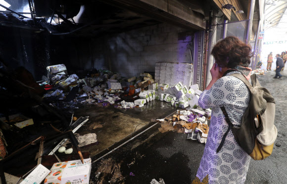 21일 새벽 서울 청량리 청과물 시장에서 화재가 발생했다. 화재 소식에 시장을 찾은 상인이 타버린 물건과 점포를 보고 눈물을 흘리고 있다. 2020.9.21 <br>연합뉴스