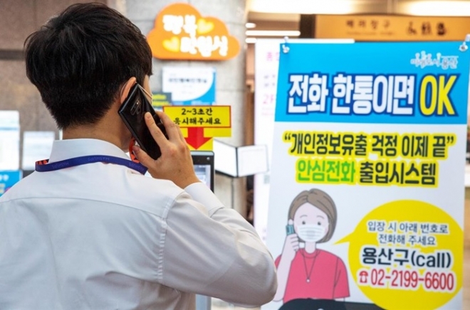 21일 용산구 종합행정타운을 방문한 민원인이 ‘발신자 전화번호 출입자 관리 시스템’을 이용해 출입을 확인하고 있다.  용산구 제공