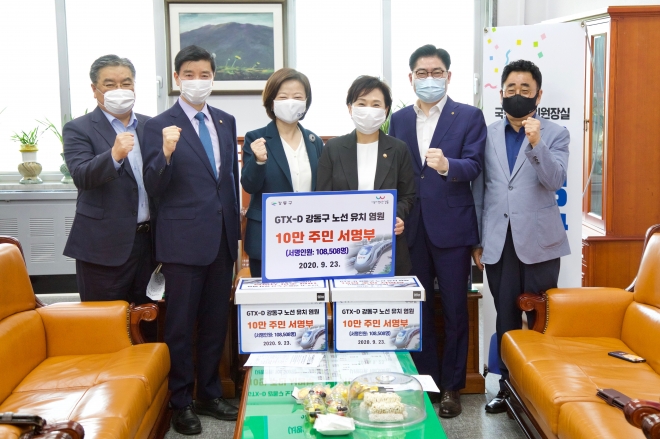 23일 국회 국토교통위원장실에서 이정훈(왼쪽 다섯번째) 강동구청장이 GTX-D 유치 10만 주민 서명부를 김현미(왼쪽 네번째) 국토교통부 장관에게 전달한 뒤 기념사진을 촬영하고 있다.   강동구 제공