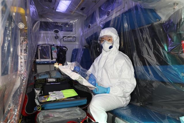 서울 중부소방서 감염증 전담구급대에서 근무하는 서아람 소방교가 개인보호복을 갖춰 입고 내부에 비닐을 설치한 구급차에 앉아 있다. 서 소방교는 “고글과 마스크, 장갑, 덧신 등 개인보호장비를 착용하고 환기가 되지 않는 응급차에서 환자를 이송하다 보면 사우나에 앉아 있는 듯한 느낌이 든다”고 말했다. 서울 중부소방서 제공
