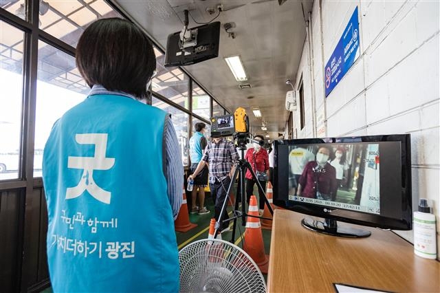 지난 23일 서울 광진구 관계자가 동서울터미널에서 하차객을 대상으로 발열 체크를 하고 있다. 광진구 제공